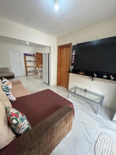 een woonkamer met een grote flatscreen-tv bij Casa in Bombinhas