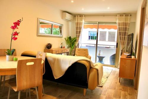 un soggiorno con un divano e un tavolo di Appartement Cosy a Cannes