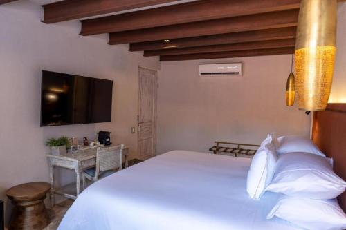 een slaapkamer met een groot wit bed en een tafel bij Hotel Casa Don Luis by Faranda Boutique, a member of Radisson Individuals in Cartagena