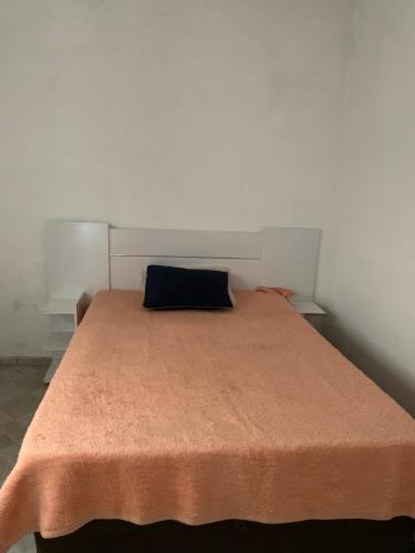 a bed with a blue pillow on top of it at Casa para Reveillon - cururupe in Ilhéus