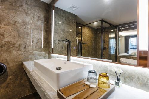 a bathroom with a white sink and a mirror at Marquis Hotel in Ban Bang Toei (1)