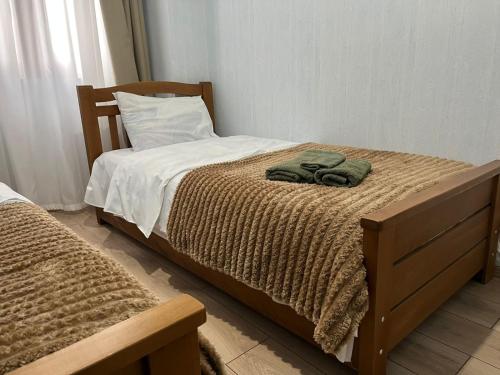 een slaapkamer met een bed met een houten hoofdeinde bij Mika's Apartment in Tbilisi City