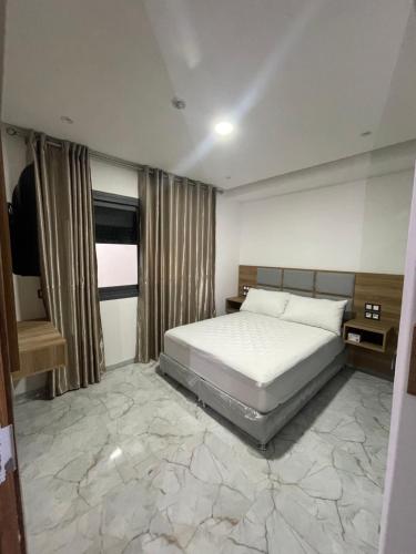 a bedroom with a bed with a large marble floor at Hôtel kairouan in Fez