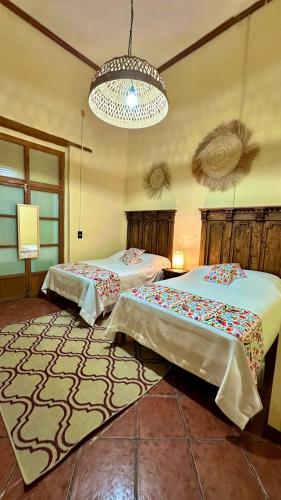 a bedroom with two beds and a chandelier at Casona Bartolome in Morelia