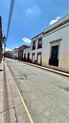 an empty street with buildings on the side of the road at Casona Bartolome in Morelia