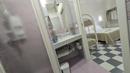 a hospital room with a bed and a mirror at Casa Lu Salentu - Monolocale superior in Torre Lapillo