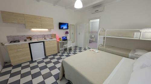 a hospital room with a bed and a kitchen and a kitchen at Casa Lu Salentu - Monolocale superior in Torre Lapillo