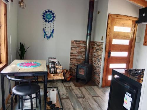 een keuken met een tafel en een fornuis in een kamer bij Cabañita con o sin Tinaja Ruta657 in Coihaique