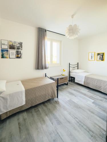 a hotel room with two beds and a window at B&B Il Grande Cipresso Recanati in Castelnuovo