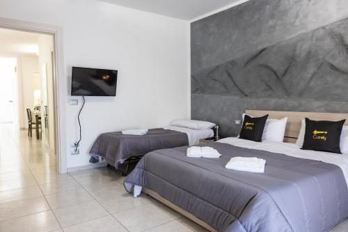 a hotel room with two beds and a flat screen tv at Cairoly Residence in Termoli