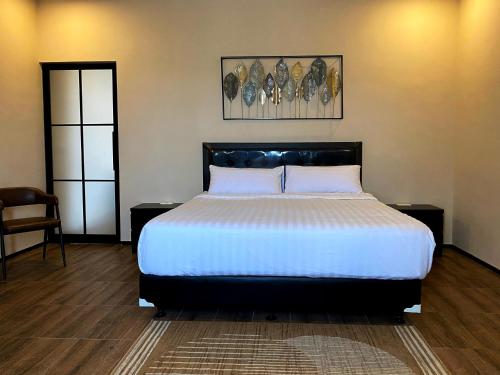 een slaapkamer met een bed en 2 tafels en een stoel bij Zalfa Hills 