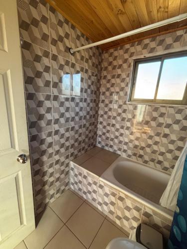 un bagno con vasca e finestra di Cabañas Vitalis a Curanipe