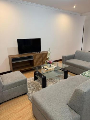 een woonkamer met twee banken en een flatscreen-tv bij Apartamento Cómodo cerca del centro in Loja
