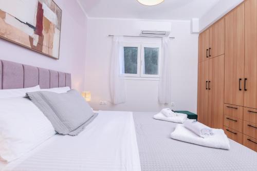 a bedroom with two white beds and a window at Smart Home Corfu 4 in Alykes Potamou