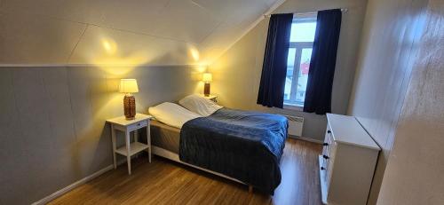 ein kleines Schlafzimmer mit einem Bett und einem Fenster in der Unterkunft Vårsol Overnatting i Vardø centrum in Vardø