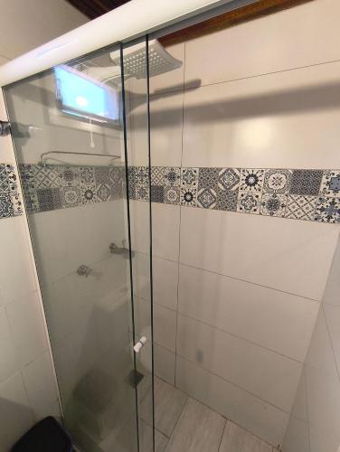 La salle de bains est pourvue d'une douche en verre et de carrelage. dans l'établissement Chalé Diamante c /AR, à Volta Redonda