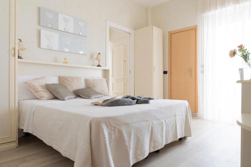 a white bedroom with a bed with a white blanket at Mondial Beauty Suite in Bellaria-Igea Marina