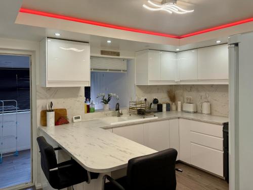 a kitchen with white cabinets and a table with chairs at Modern Elegant Home in Portsmouth
