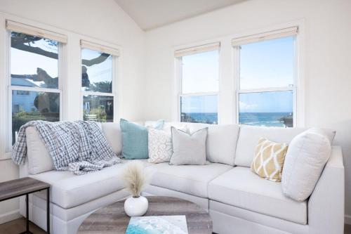 a white couch in a living room with windows at Oceanview Beach Home Walk to Beach Trails Food Family Activities in Montara