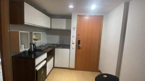 eine Küche mit weißen Schränken und einer braunen Tür in der Unterkunft Tropical Executive in Manaus