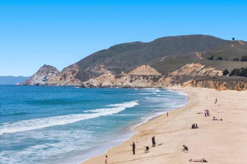 a group of people on a beach near the ocean at Oceanview Beach Home Walk to Beach Trails Food Family Activities in Montara