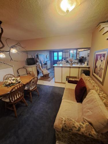 een woonkamer met een bank en een tafel en een keuken bij Karachalios Maisonette in Karyes