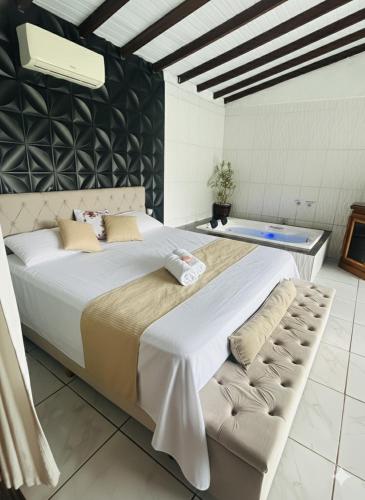 a large bed in a room with a black wall at Chalé cipreste 4 Quartos in Gramado