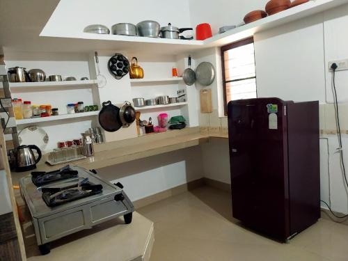 een keuken met een fornuis en een koelkast bij Nature's View Service Villa in Vythiri