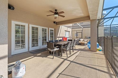 a patio with a table and chairs and a ceiling fan at Enjoyable 6BR Home Near Disney in Orlando