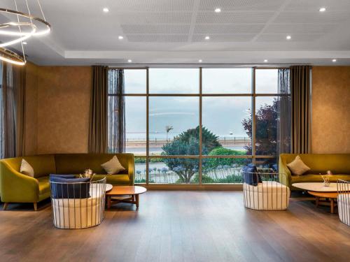 een lobby met banken en tafels en een groot raam bij Novotel Istanbul Zeytinburnu in Istanbul