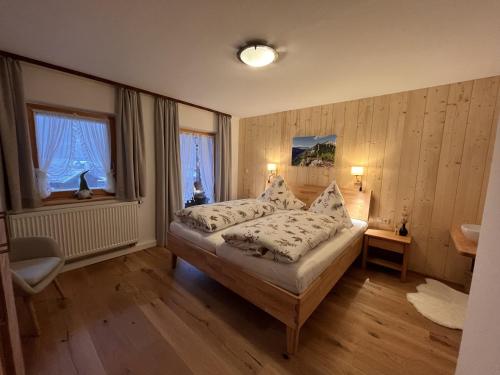 ein Schlafzimmer mit einem Bett und zwei Fenstern in der Unterkunft Ferienhaus Hallweger inkl. Chiemgaukarte in Ruhpolding