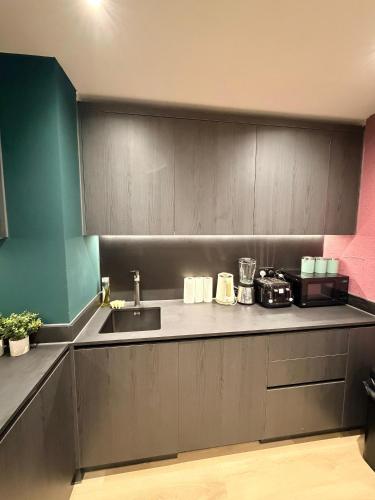 a kitchen with a sink and a counter at Luxury 2bed flat around Manchester Victoria St in Manchester