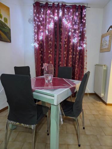 ein Esstisch mit Stühlen und einem roten Vorhang in der Unterkunft Casa Friend in Castel di Sangro