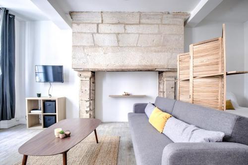 een woonkamer met een bank en een tafel bij Wisdom at heart in Périgueux