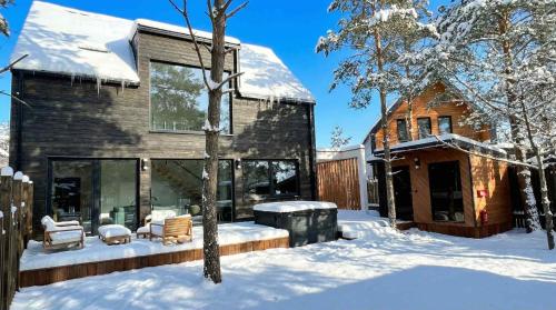 ein Haus im Schnee mit überdachtem Garten in der Unterkunft Willa Horyzont Borsk in Borsk