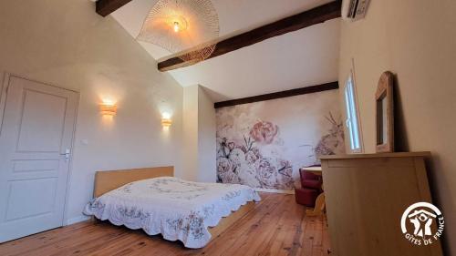 een slaapkamer met een bed en een schilderij aan de muur bij L'esquirou in Lagarrigue