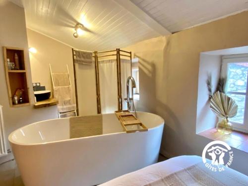 een groot wit bad in een badkamer met een douche bij Casa d'amunt in Prats-de-Mollo-la-Preste