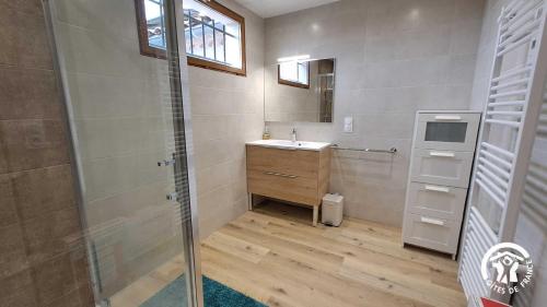 een badkamer met een wastafel en een glazen douche bij L'esquirou in Lagarrigue