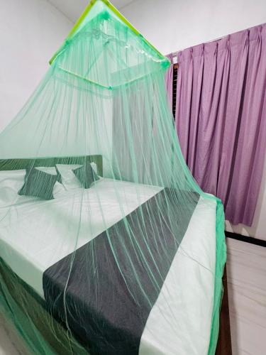 a bed with a mosquito net on top of it at Villa Nevya in Weligama