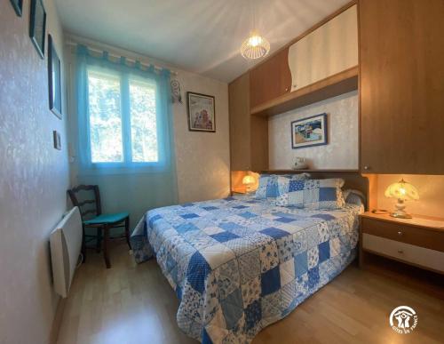een slaapkamer met een blauw en wit bed en een raam bij Le moulin in Sahorre