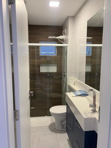 een badkamer met toilet en glazen douche bij Ap completo in Balneário Camboriú