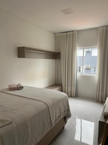 een slaapkamer met een groot bed en een raam bij Ap completo in Balneário Camboriú