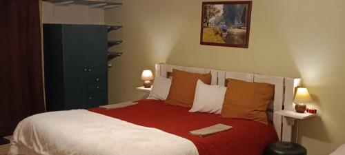 a bedroom with a large bed with red and white pillows at Aux 10 Ponts Maison spacieuse et conviviale au bord de la Somme la mer à 30 min 6 personnes in Pont-Rémy