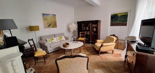 a living room with a couch and a table and chairs at Maison boutet 9 in Fanjeaux
