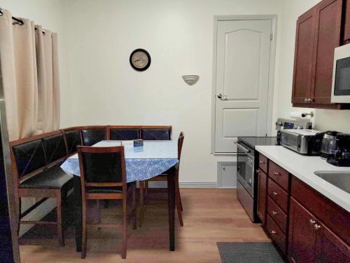 une cuisine avec une table et des chaises et une horloge au mur dans l'établissement Welcoming & Spacious 2-Bedroom Guest Suite in Torrance 20 Minutes from LAX, à Torrance