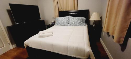une chambre avec un grand lit avec des draps et des oreillers blancs dans l'établissement Welcoming & Spacious 2-Bedroom Guest Suite in Torrance 20 Minutes from LAX, à Torrance