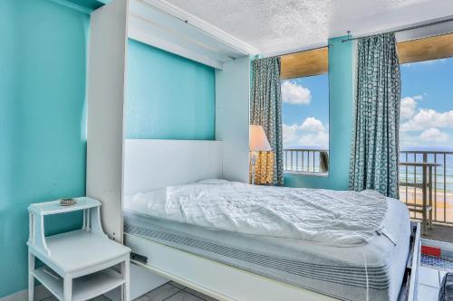 una camera da letto con un letto e una finestra di Daytona Seagull's Nest Harbour Beach 608 a Seabreeze