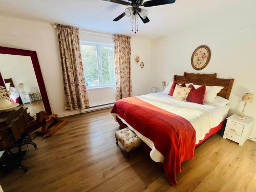 a bedroom with a bed and a ceiling fan at Chalet -Havre au bord de l'eau in Chertsey