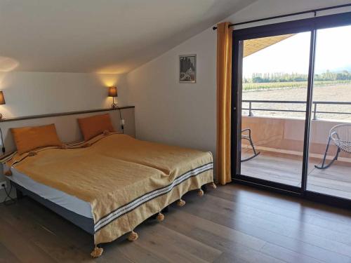 une chambre avec un lit et une porte coulissante en verre dans l'établissement Eucalyptus, à Thuir