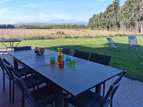 une table bleue avec des chaises et une bouteille de vin dans l'établissement Eucalyptus, à Thuir